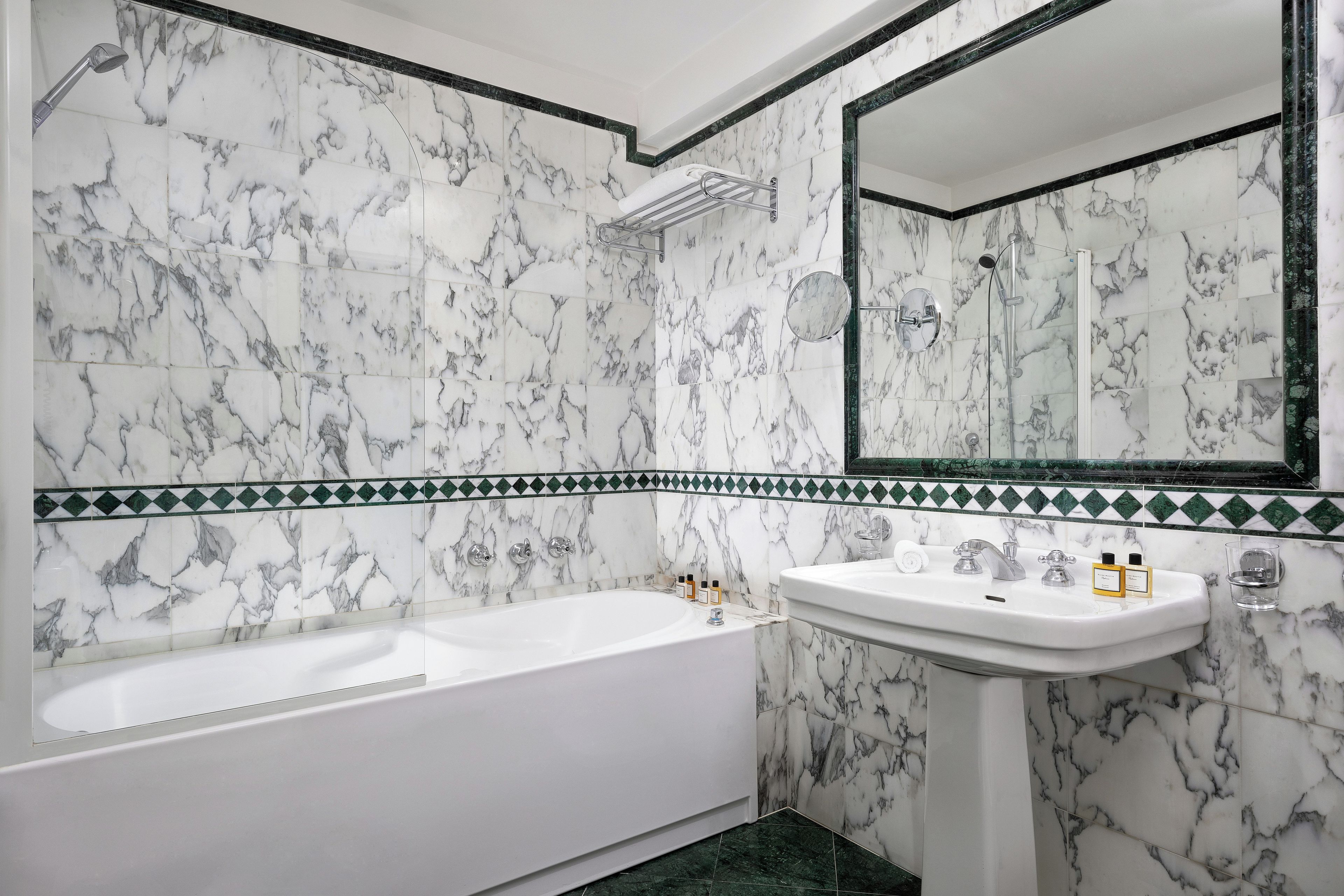 Un baño con bañera, lavamanos y espejo.