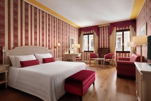 A hotel room with a large bed, a desk, two chairs, a small table, and a television. - Sina Palazzo Sant'Angelo (Venice)