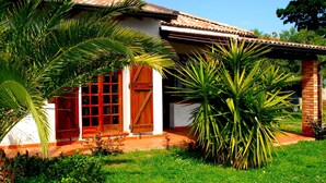 Una casa con techo de tejas, fachada de ladrillo y porche cubierto.