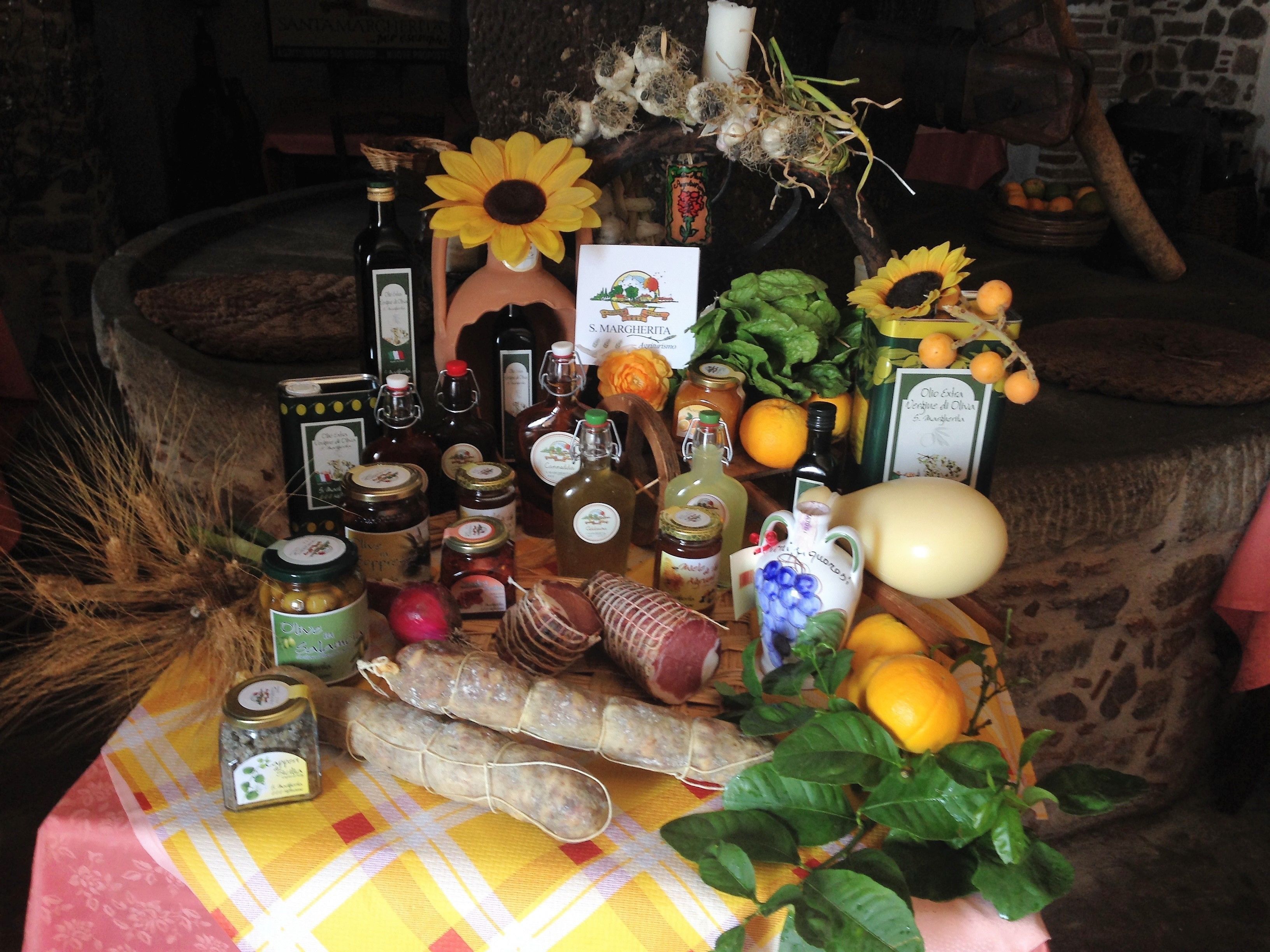 A table with various food items and bottles, including jars, bottles, and a loaf of bread.