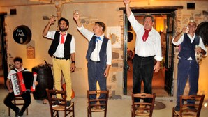 Un grupo de personas en un interior rústico con paredes de piedra y sillas de madera.