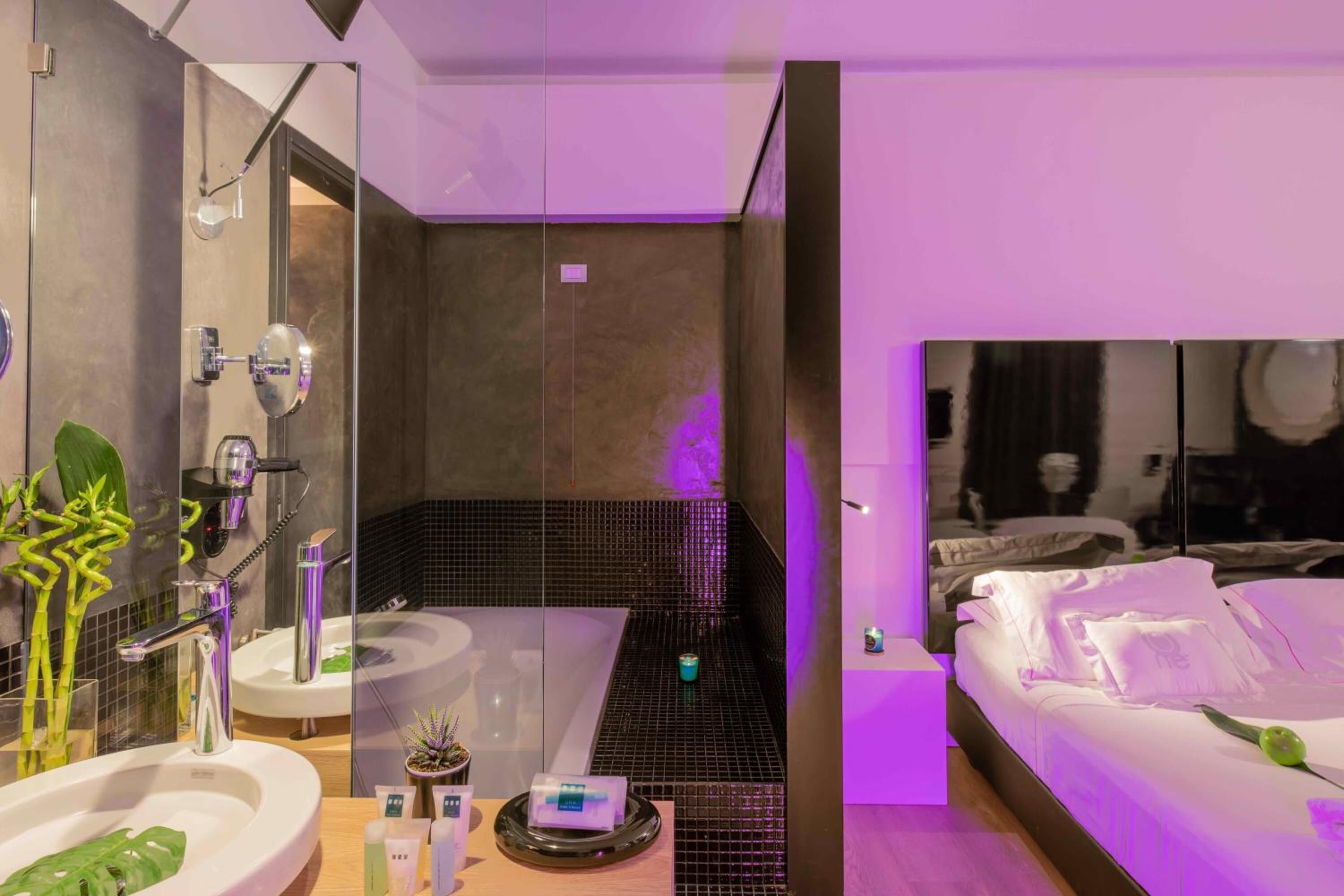 Un baño moderno con un espejo grande, un lavamanos y una zona de ducha.