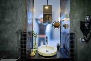 A modern bathroom with a large sink, a mirror, and a telephone.