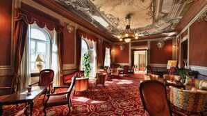 A grand room with ornate ceiling, red carpet, and classic furniture. - Hotel Eden Levico Terme (Levico Terme)