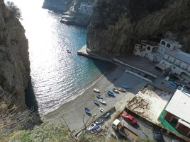 Un pueblo costero con playa, barcos y edificios.