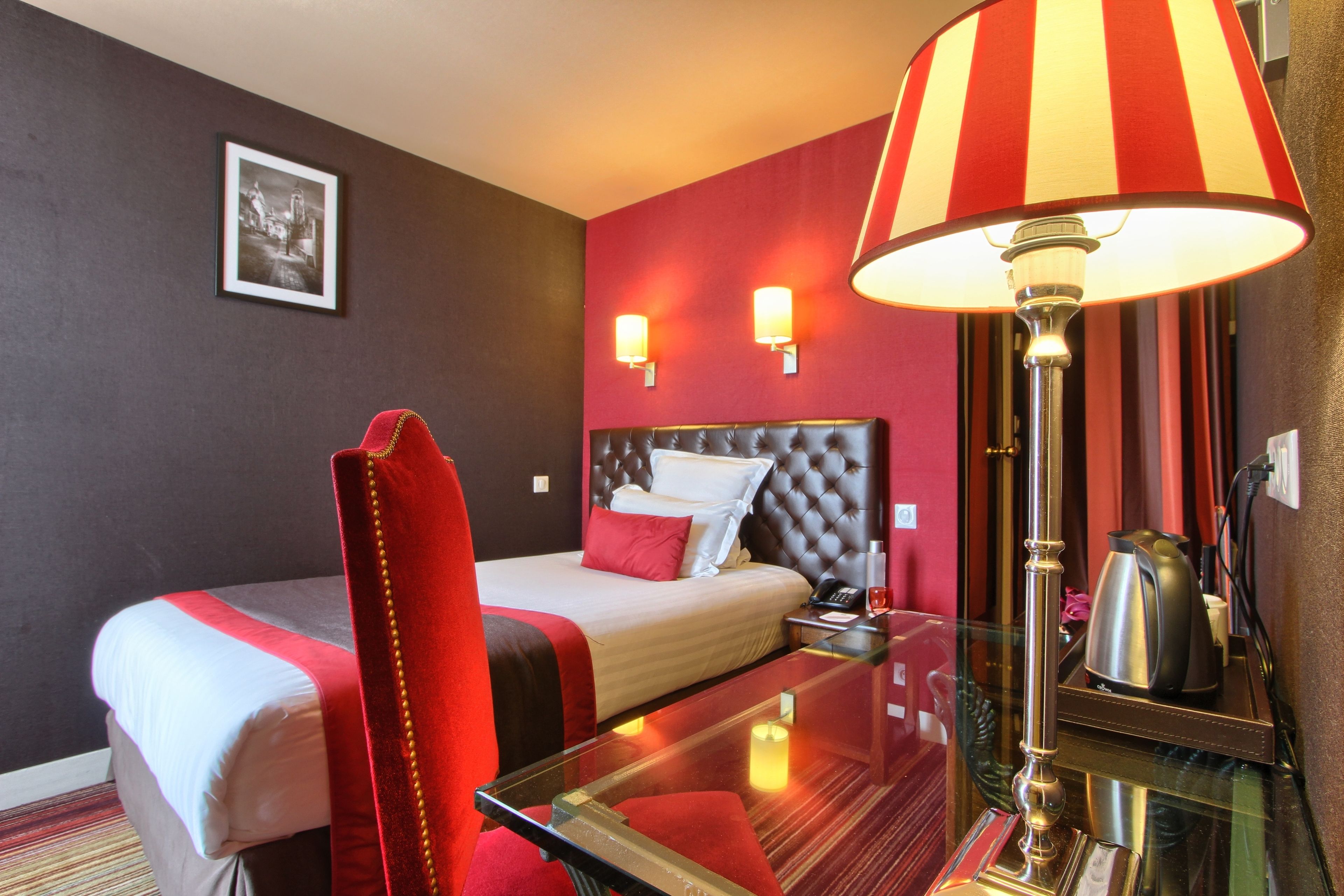 Een hotelkamer met een bed, een stoel, een tafel en een lamp.
