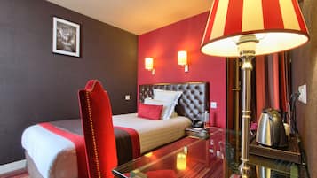 Une chambre d’hôtel avec un lit, une chaise, une table et une lampe.