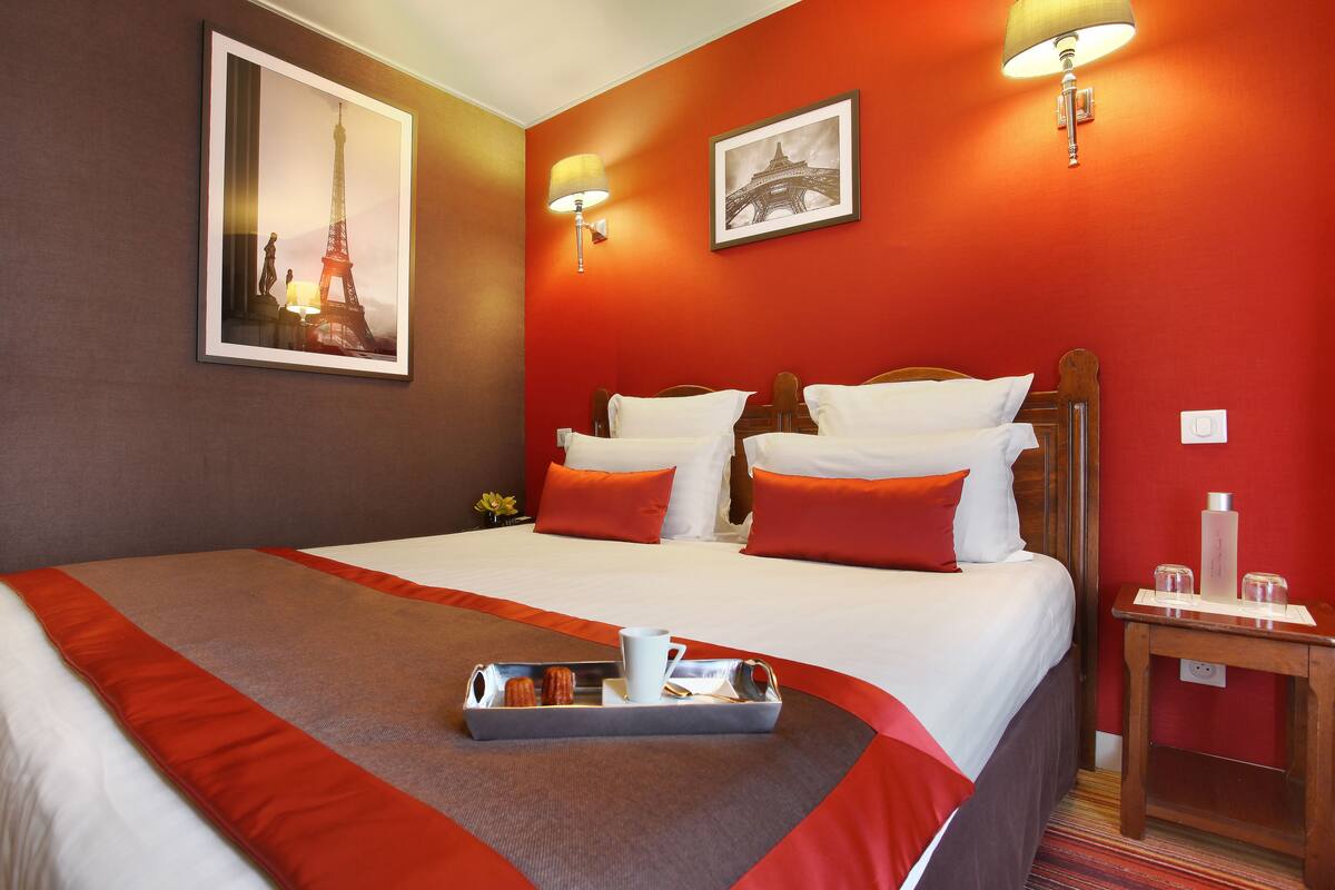 Ein Hotelzimmer mit einem Bett, einem Tablett mit Frühstücksangeboten und zwei Wandlampen.