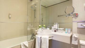 A modern bathroom with a glass-enclosed shower, a white sink, and a large mirror.