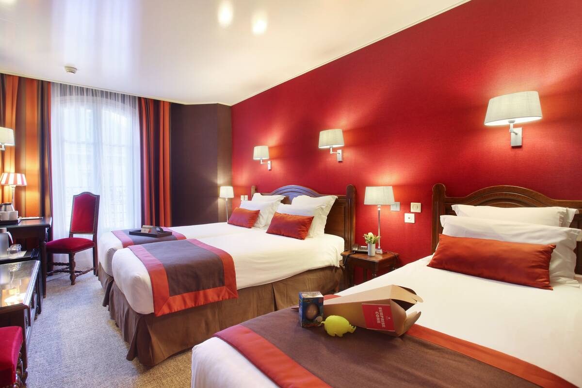 Ein Hotelzimmer mit zwei Betten, einem Schreibtisch und einem Stuhl.