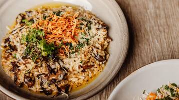 Uma tigela de comida com arroz, cogumelos e cenoura ralada.