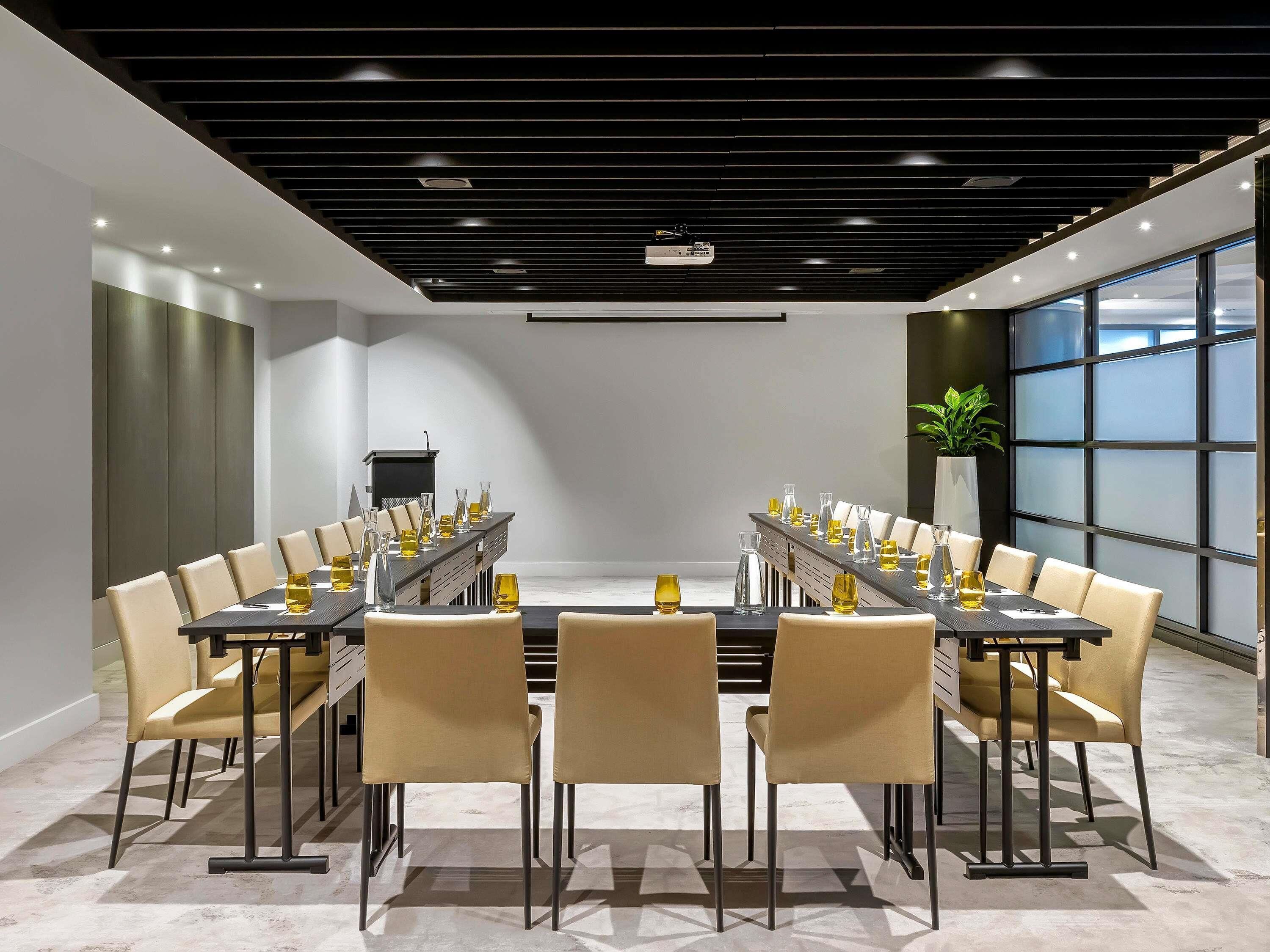 A conference room with a long table, chairs, and a projector.