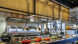 A modern kitchen with stainless steel appliances, hanging pendant lights, and a buffet setup. - Peppers Waymouth Adelaide (Adelaide)