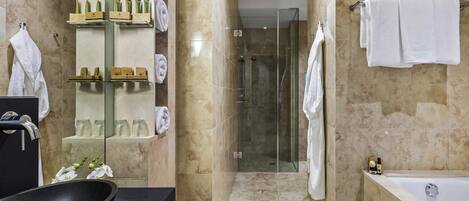 A modern bathroom with a glass-enclosed shower, a bathtub, and a vanity with a black sink.