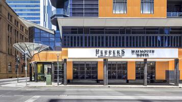 Un hôtel à l’architecture moderne, doté de grandes fenêtres et d’une enseigne bien visible indiquant « Peppers Waymouth Hotel ».