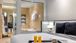 A hotel room with a bed, breakfast tray with fruit and juice, and a newspaper. - Peppers Waymouth Adelaide (Adelaide)