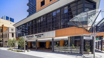 Exterior del Waymouth Hotel, con un diseño moderno, que cuenta con grandes ventanales y una entrada destacada.