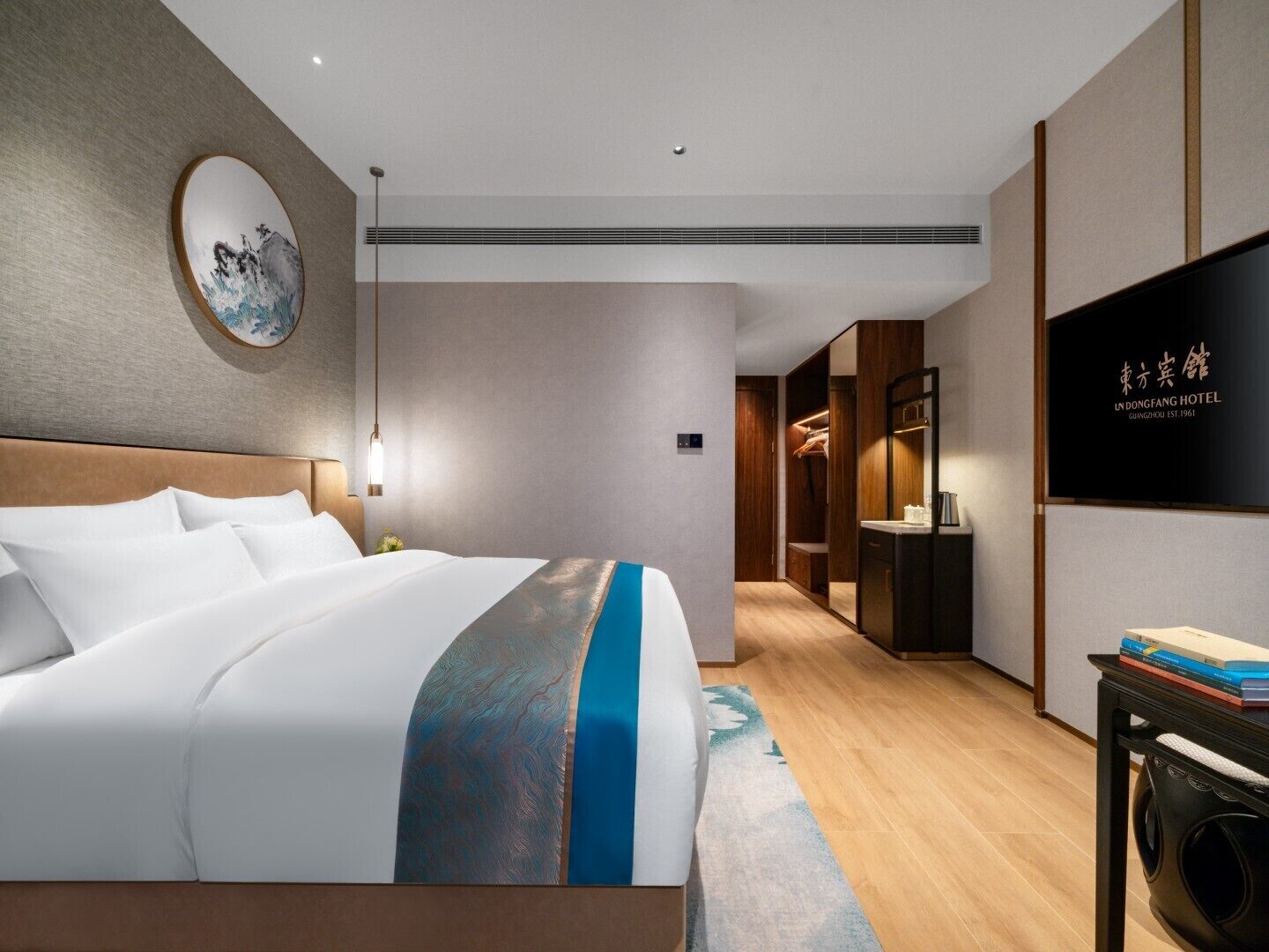 Una habitación de hotel moderna con una cama grande, televisión y armario.
