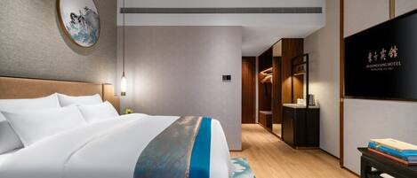 Una habitación de hotel moderna con una cama grande, televisión y armario.
