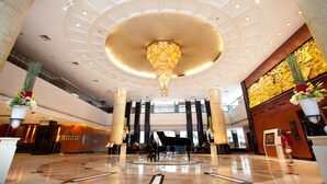 A spacious lobby with a grand chandelier, marble columns, and a piano. - Dong Fang Hotel Guangzhou (Guangzhou)