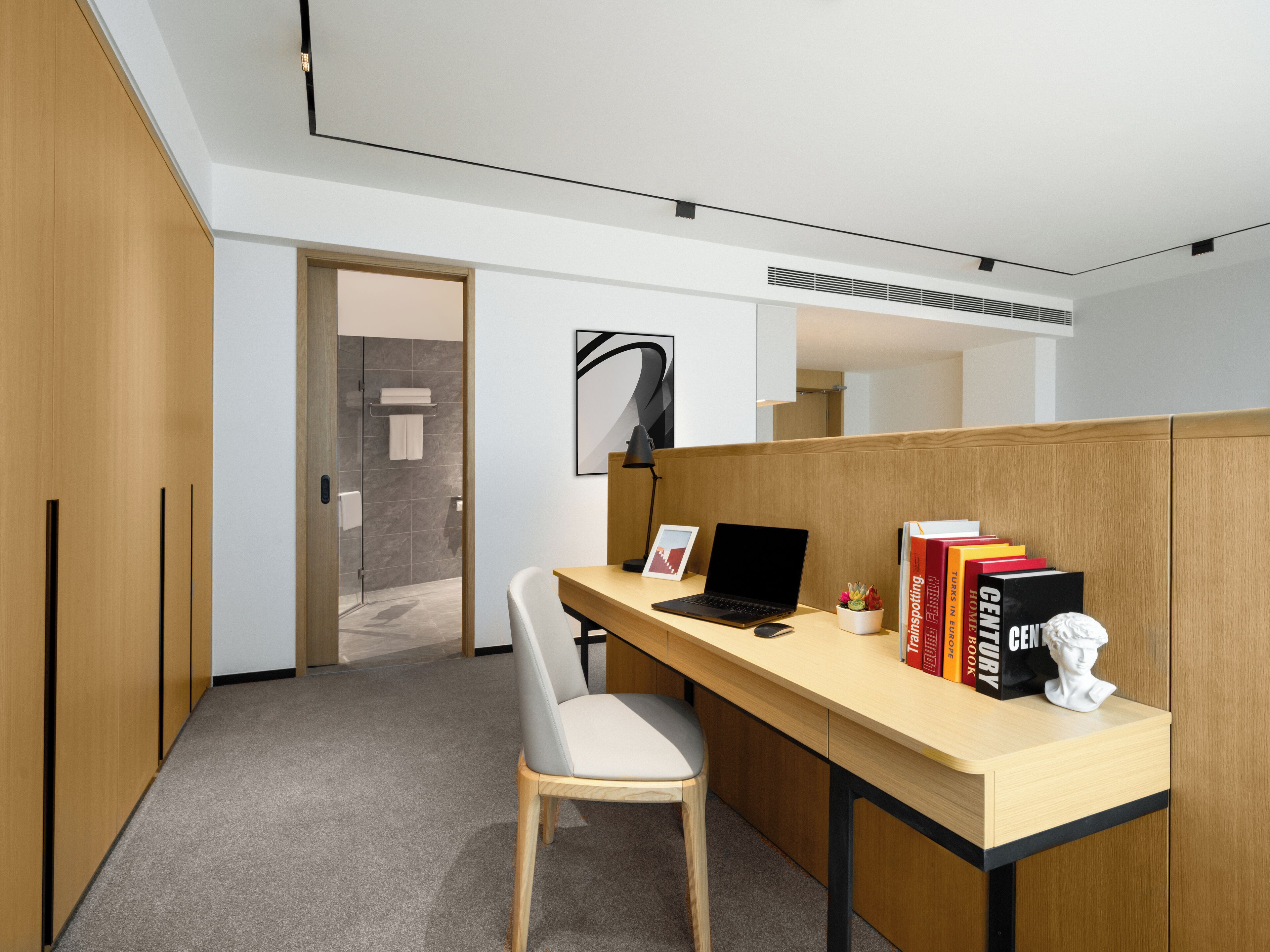 A modern office space with a desk, chair, and books.