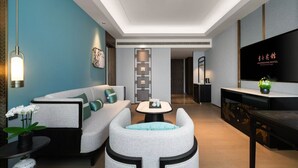 A modern hotel room with a sofa, armchair, and a small table with a tray. - Dong Fang Hotel Guangzhou (Guangzhou)