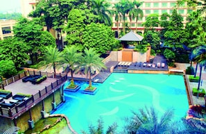 Una piscina al aire libre, sombrillas, sillones reclinables de piscina