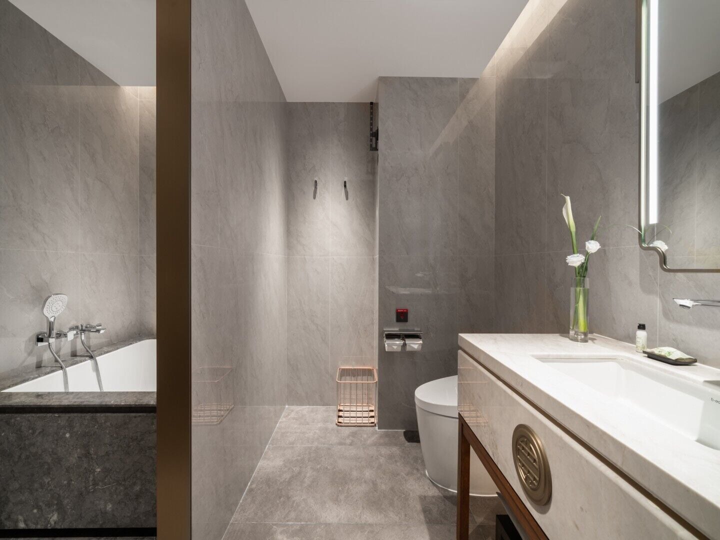 A modern bathroom with a bathtub, toilet, and sink.