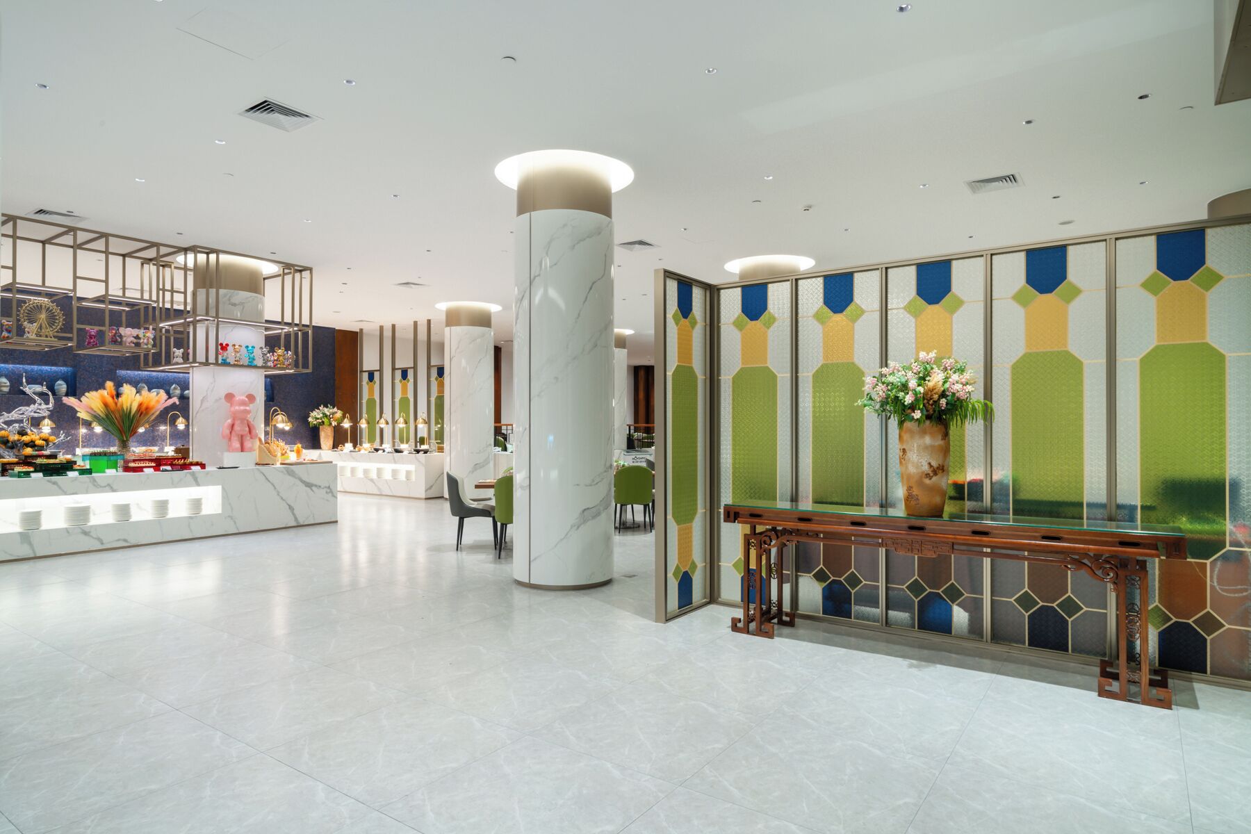 Una hall d'hotel moderna con reception, area salotto e elementi decorativi.