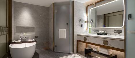 A modern bathroom with a freestanding bathtub, a large mirror, and a vanity with a towel rack.