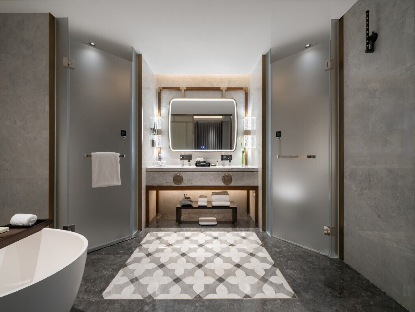 A modern bathroom with a freestanding bathtub, a large mirror, and a patterned floor.