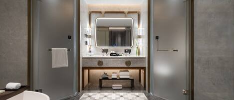 Une salle de bain moderne avec une baignoire sur pieds, un grand miroir et un carrelage décoratif.