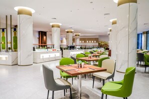 A modern hotel lobby with marble columns, green and grey chairs, and a bar area. - Dong Fang Hotel Guangzhou (Guangzhou)