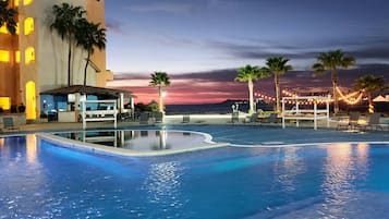 Relax by the oceanfront pool surrounded by lounge chairs and umbrellas.