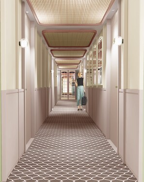 A hallway with patterned flooring, a person standing, and a door at the end. - Urban Hive Paris (Paris)
