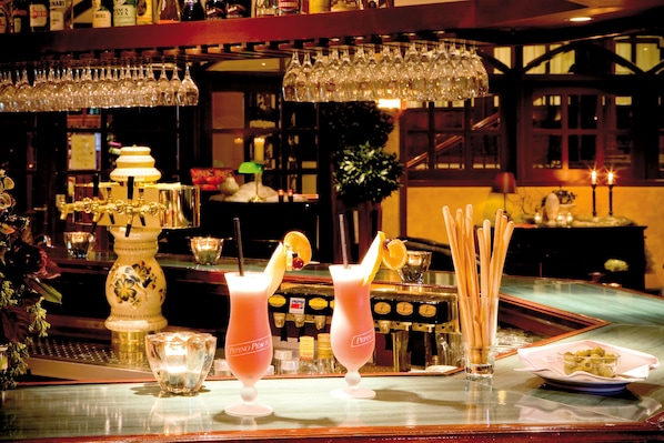 A bar area with two cocktails, a glass of water, and a plate of olives. - Van der Valk Hotel Gladbeck (Gladbeck)