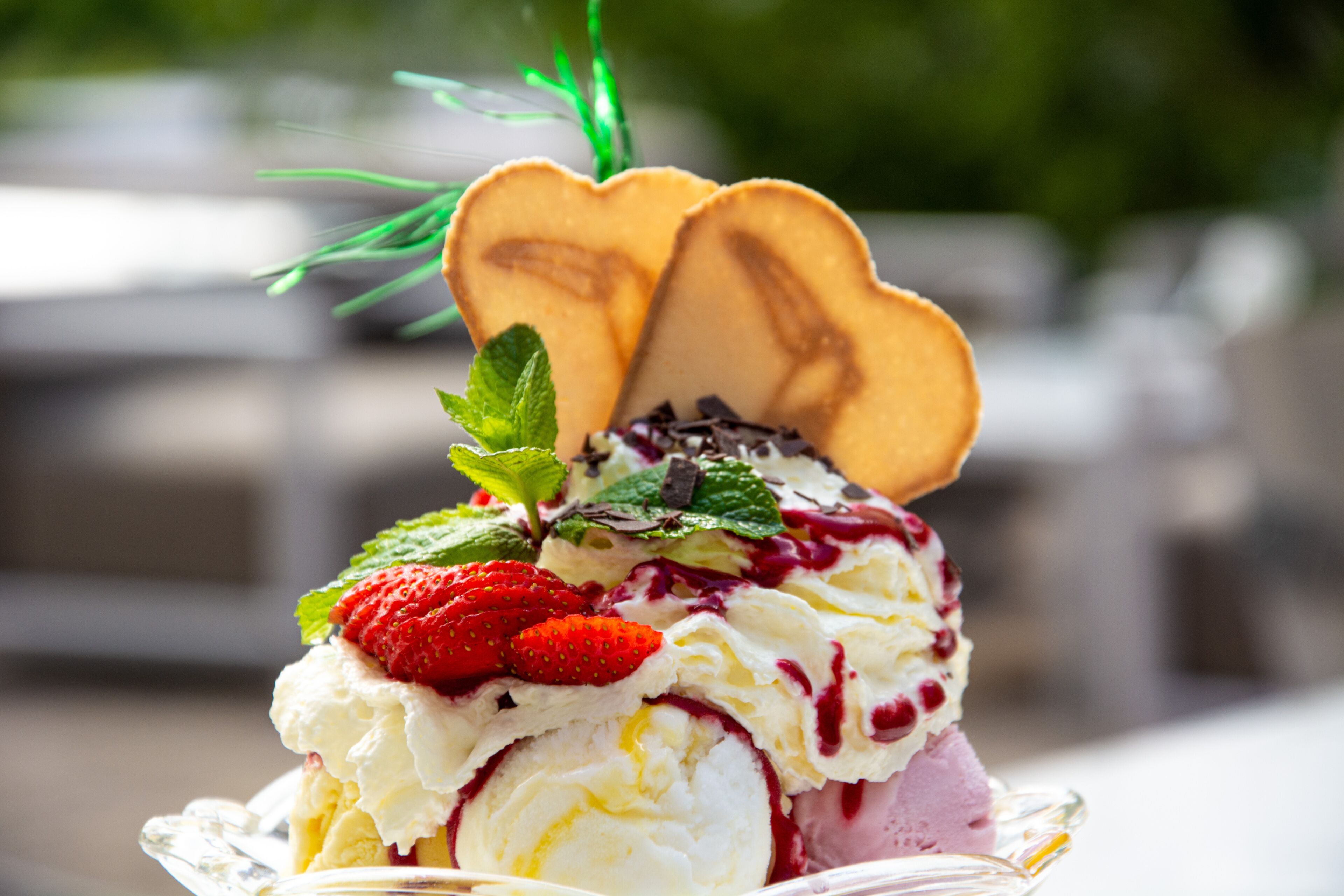 Un postre con fresas, menta y una galleta con forma de corazón encima.