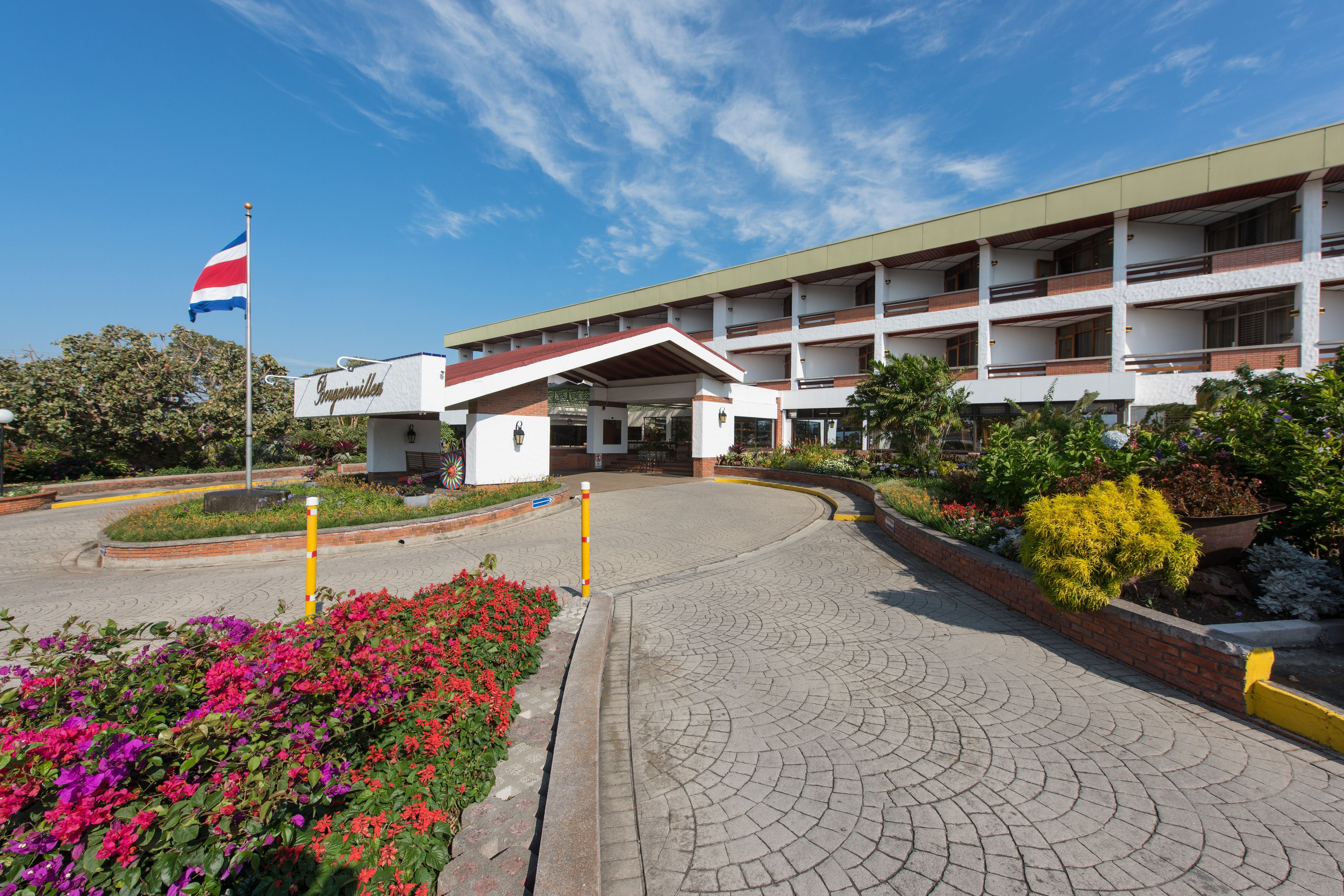 A hotel with a central entrance, multiple floors, and a flag.