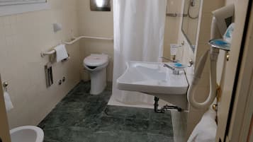 Une petite salle de bain comprenant des toilettes, un lavabo et un espace douche.