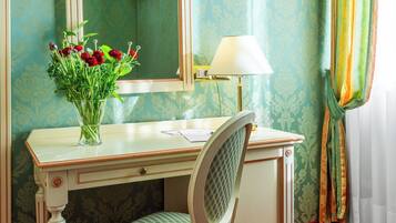 A room with a desk, a mirror, a lamp, and a chair.