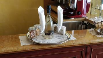 A kitchen counter with a coffee machine, a bottle of Venzia, and two napkins on a tray.