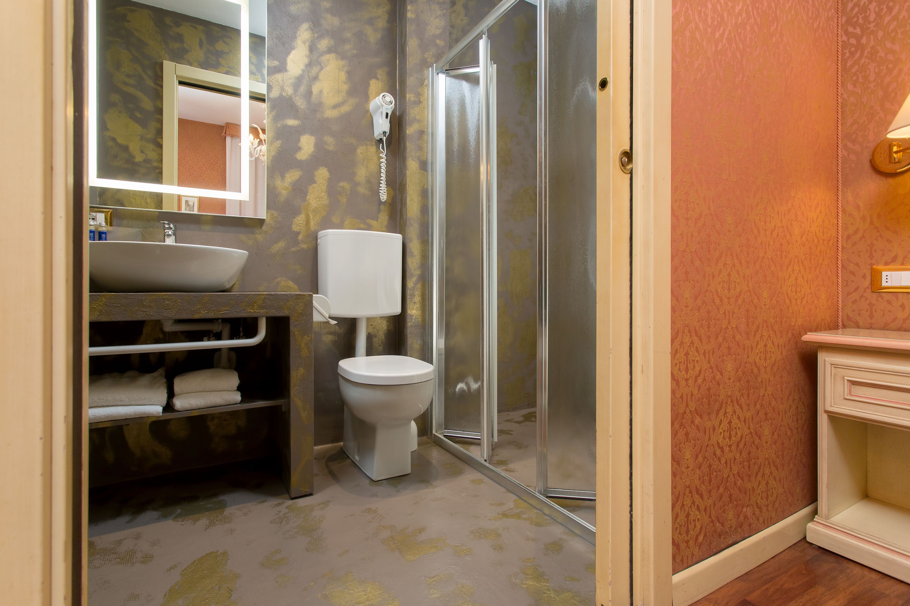 A bathroom with a sink, toilet, and shower.