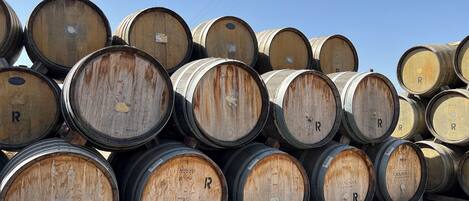 A stack of wooden barrels with the letter "R" on them, arranged on a wooden pallet.