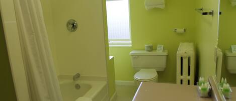 A bathroom with a bathtub, toilet, and sink.