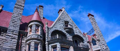 A large stone building with multiple chimneys and ornate balconies.