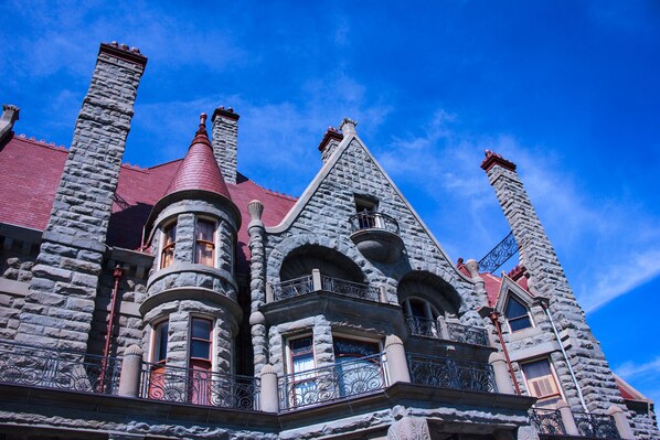 Un edificio grande de piedra con múltiples chimeneas y balcones ornamentales.