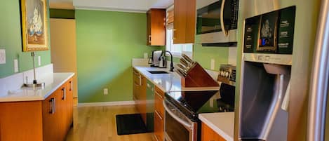 Una cocina con armarios de madera, un refrigerador de acero inoxidable y un microondas.