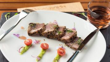 Un plato de comida con un tenedor, un cuchillo y una servilleta sobre una mesa de madera.