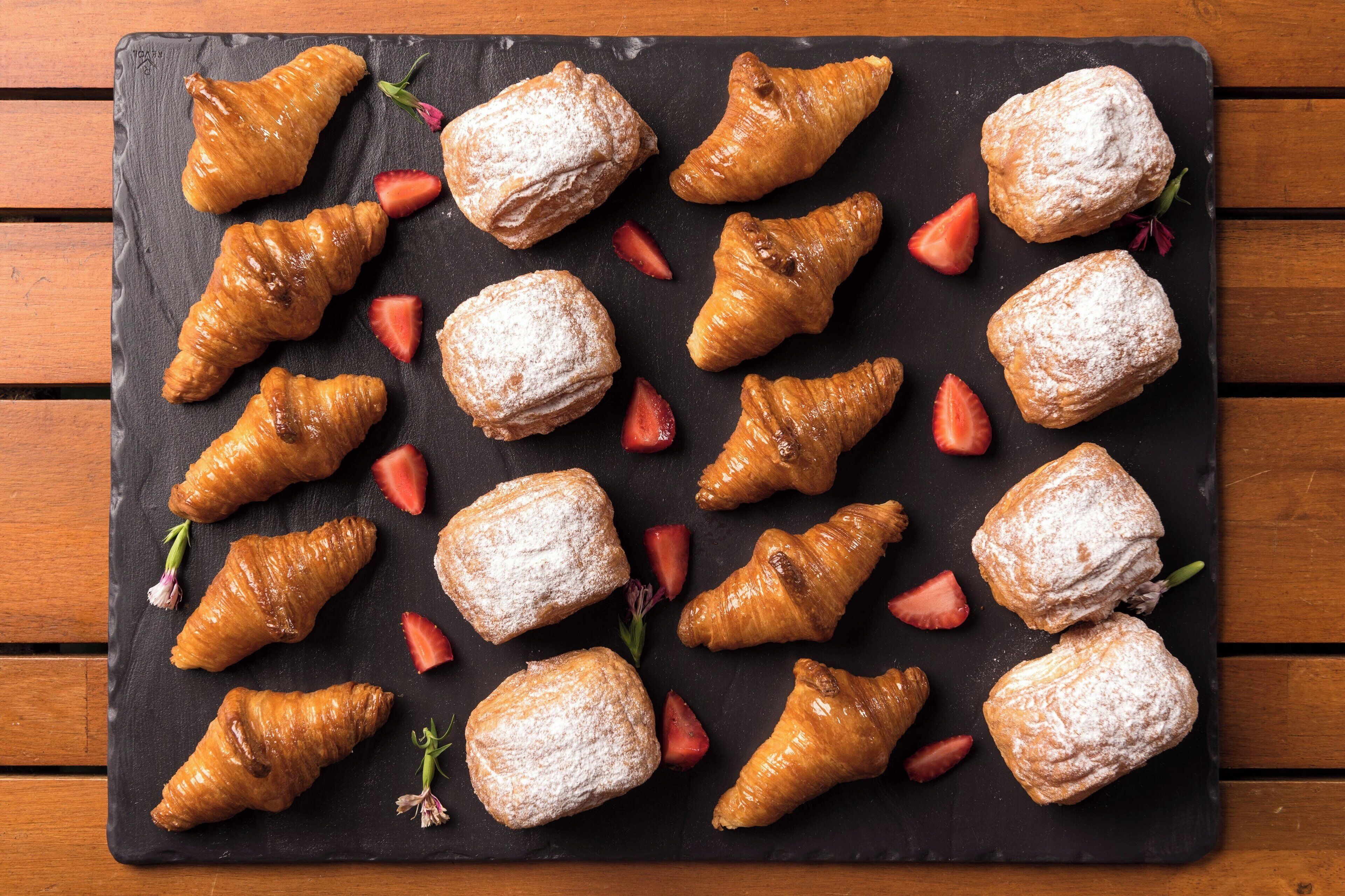 Una pizarra con pasteles y fresas.