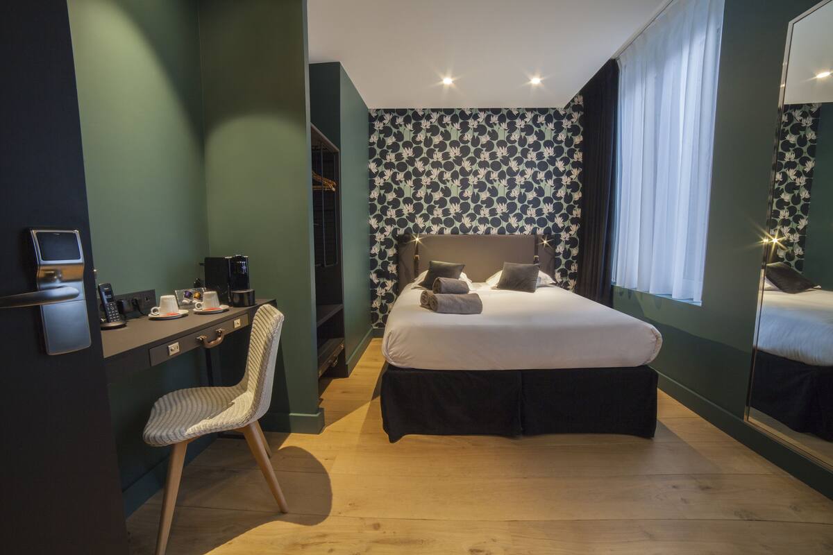 Un dormitorio con cama, escritorio, silla y armario.